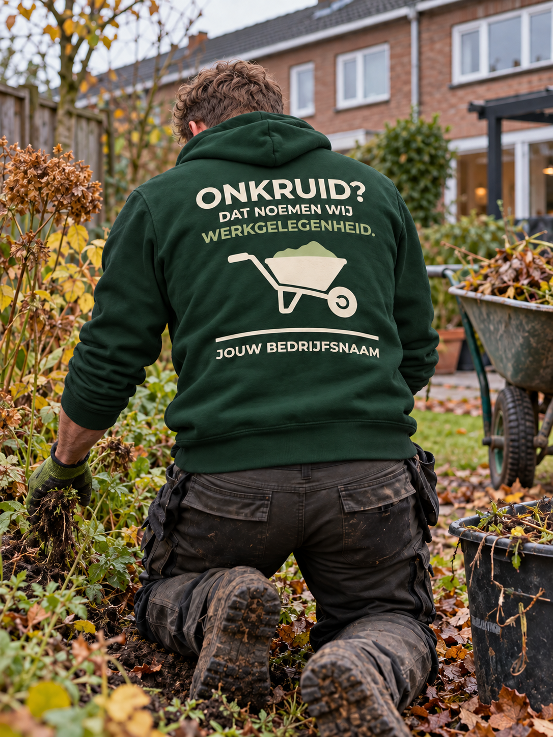 Hovenier in bosgroene hoodie met de tekst "Onkruid? Dat noemen wij werkgelegenheid" en bedrijfsnaam op de rug, knielend bij een border in de herfst